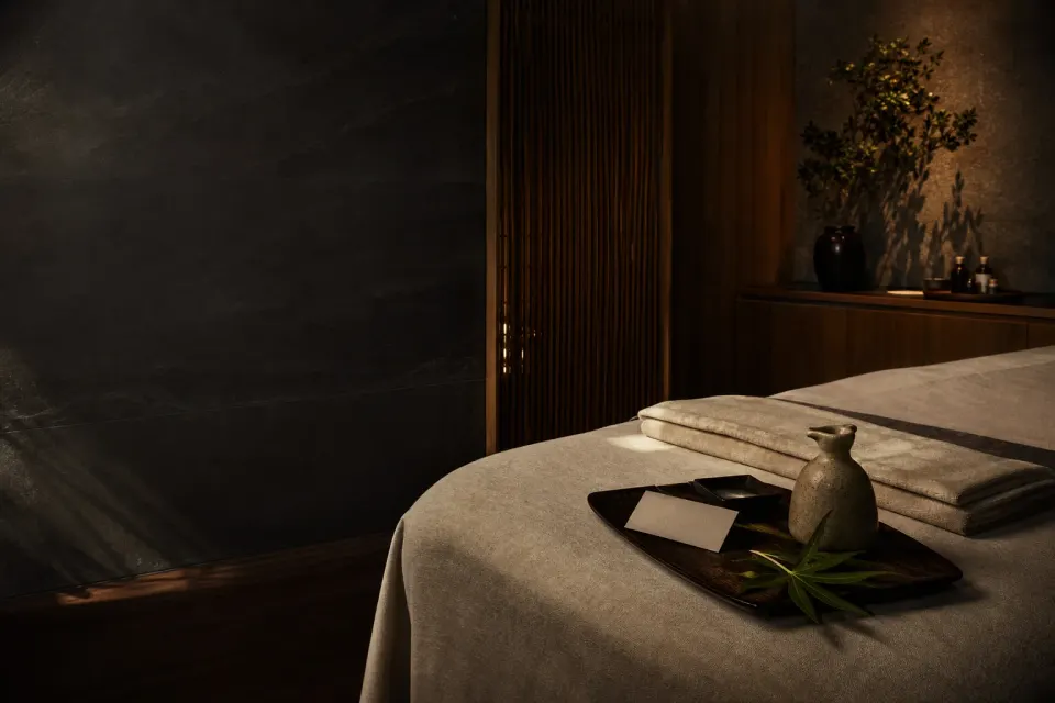 A calm massage room with linen, oil and an appointment card