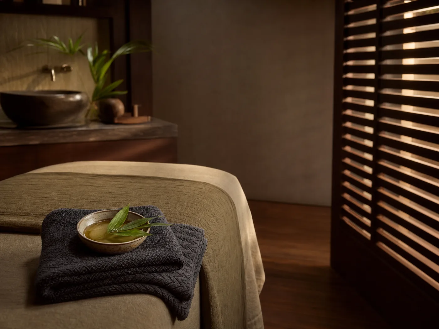 A prepared massage room with oil and folded towels