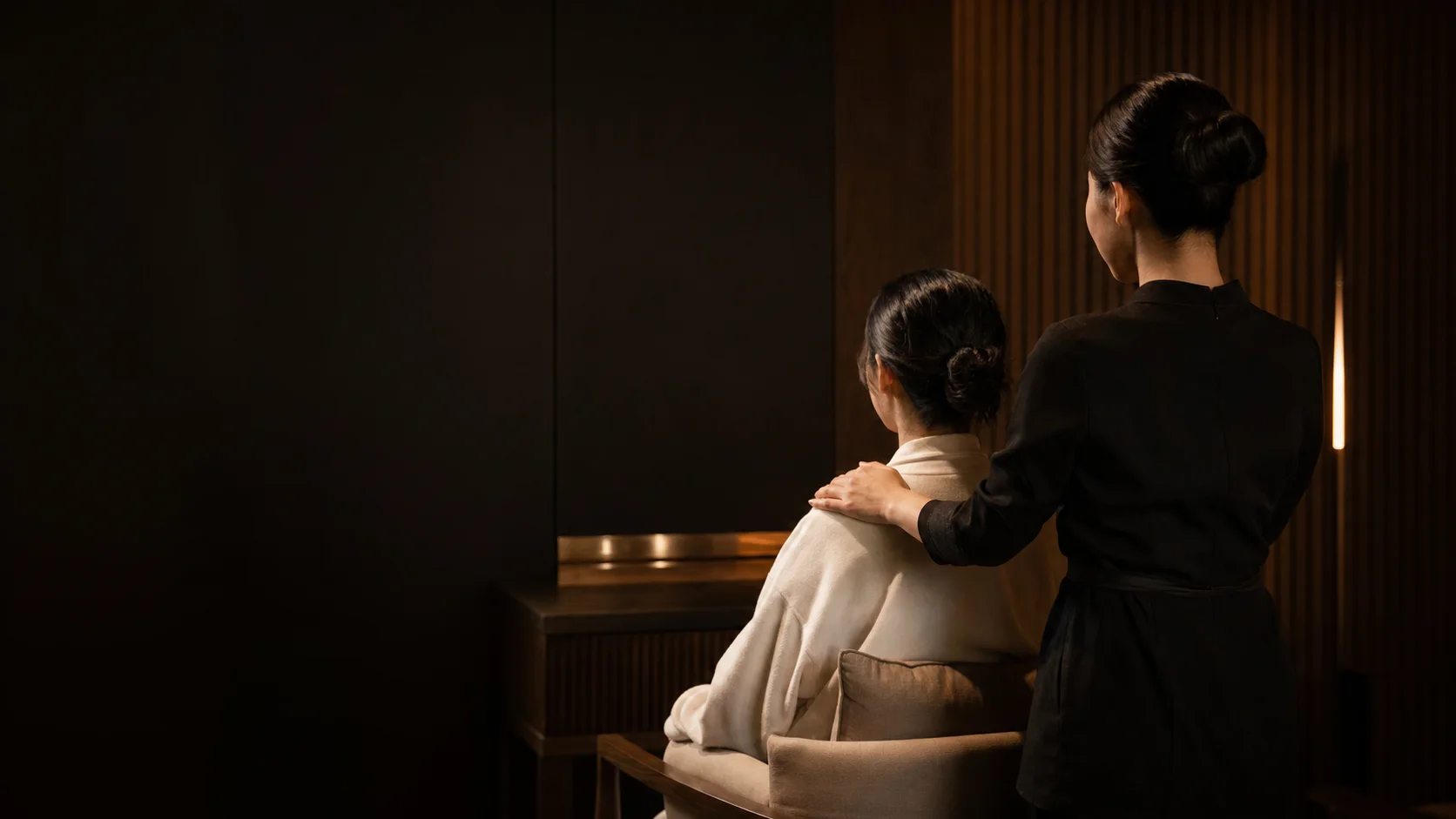 A therapist discussing shoulder pressure with a fully robed guest